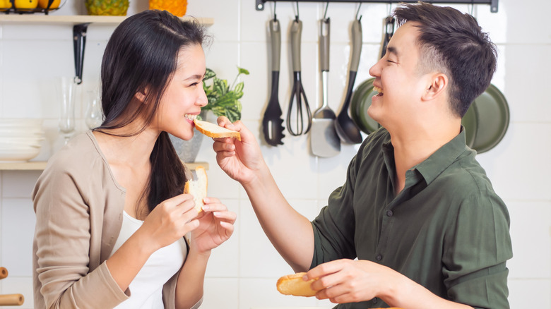 Een man die een vrouw een plak brood voedt