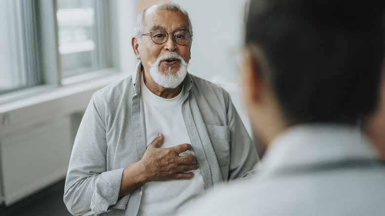 Oudere man die met arts spreekt over symptomen