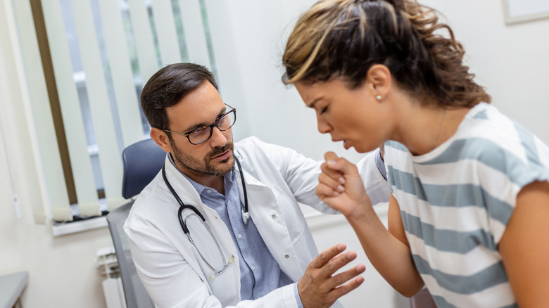 vrouw in dokterskantoor hoesten