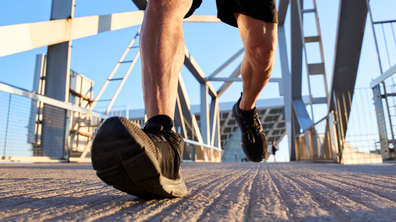 Close-up van de voeten van een man die op een brug lopen