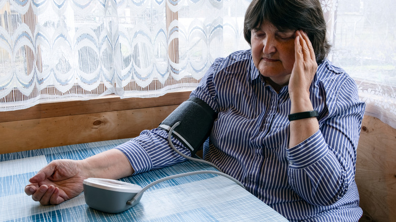 Rijpe vrouw die reageert op slechte bloeddruklezing
