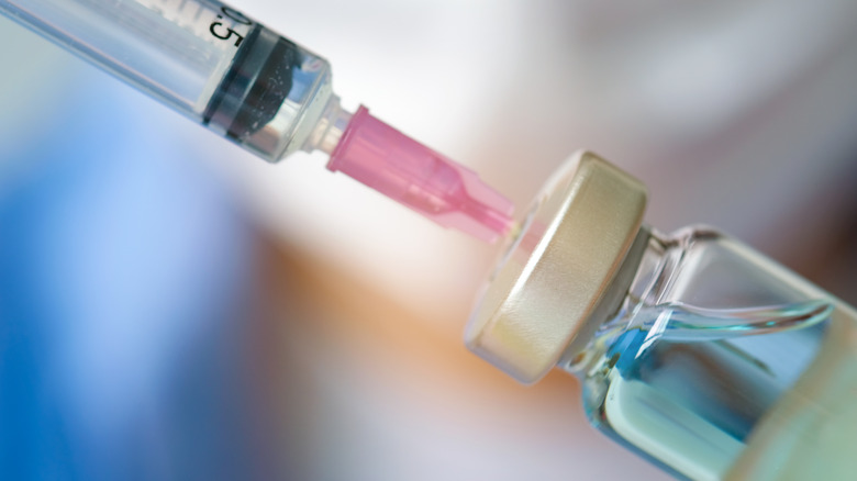 Spuit ingebracht in blauwe vaccinfles