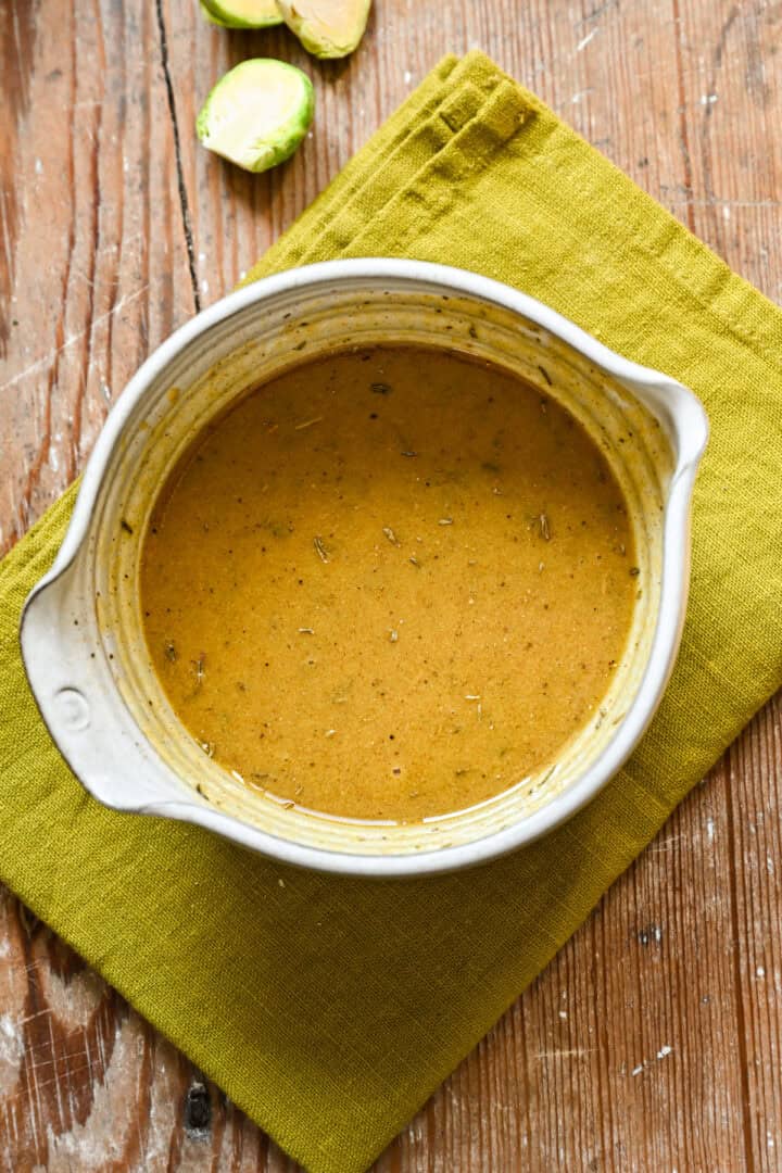 Close -upaanzicht van esdoorn mosterddressing in een witte kom.