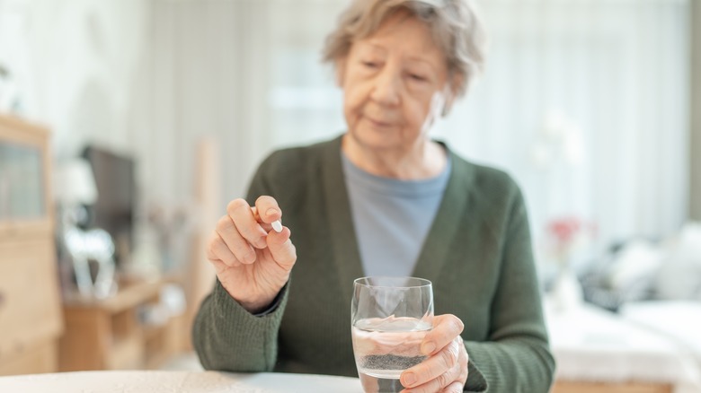 Rijpe vrouw met pil en glas water