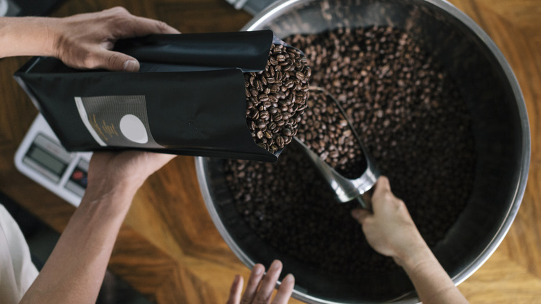 Mensen vullen tassen met koffiebonen