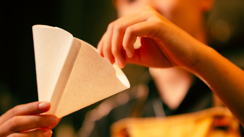 Vrouw die een papieren koffiefilter gebruikt