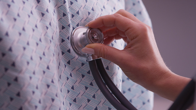 hand met stethescoop op de borst van de patiënt