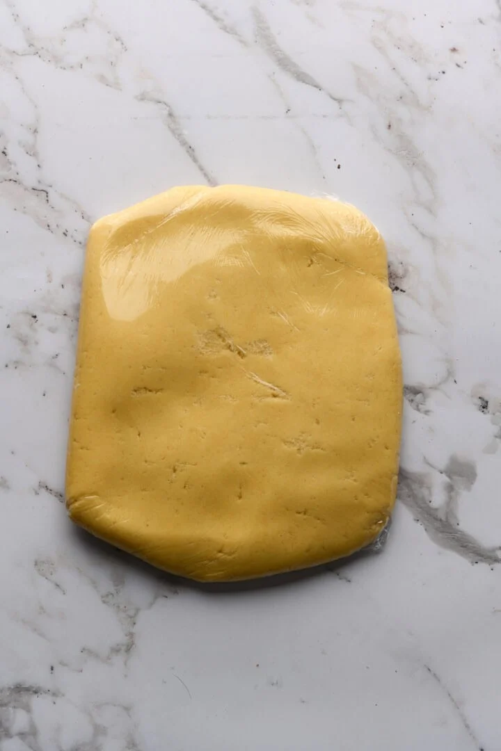 Suikerkoekjesdeeg in een rechthoek verpakt in plasticfolie.