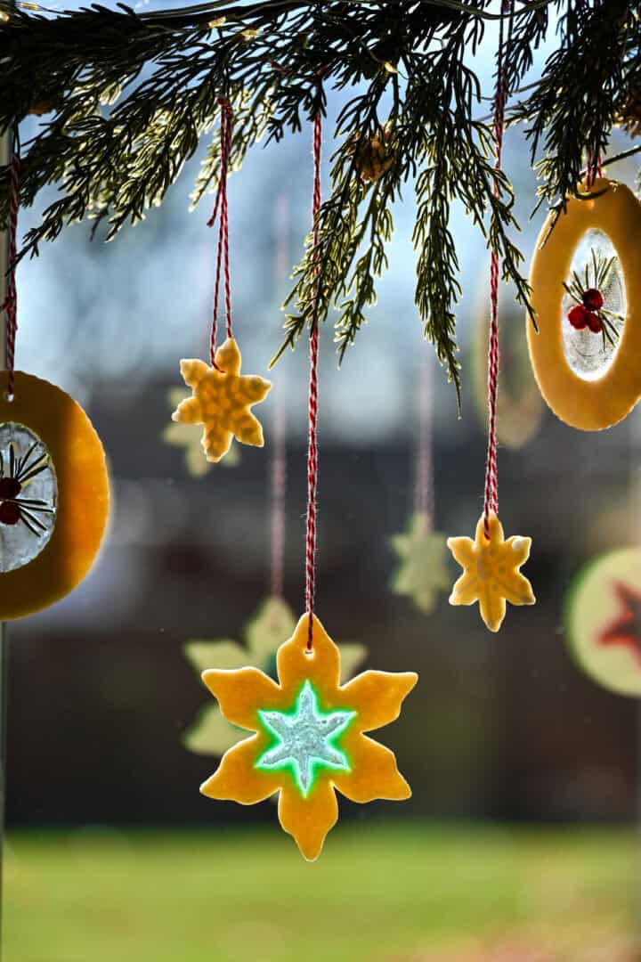 suikerkoekjes van glas-in-lood hangen aan een slinger voor een keukenraam.