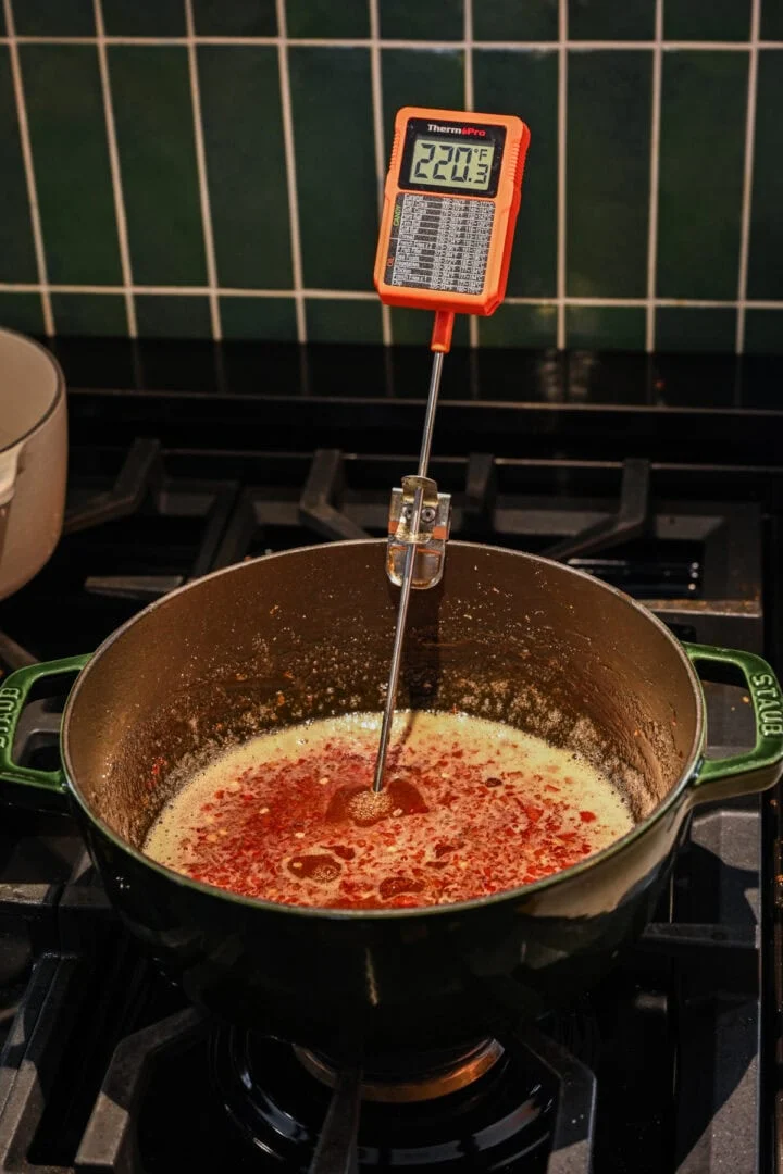 Vooraanzicht van pepergelei met thermometer in pot.