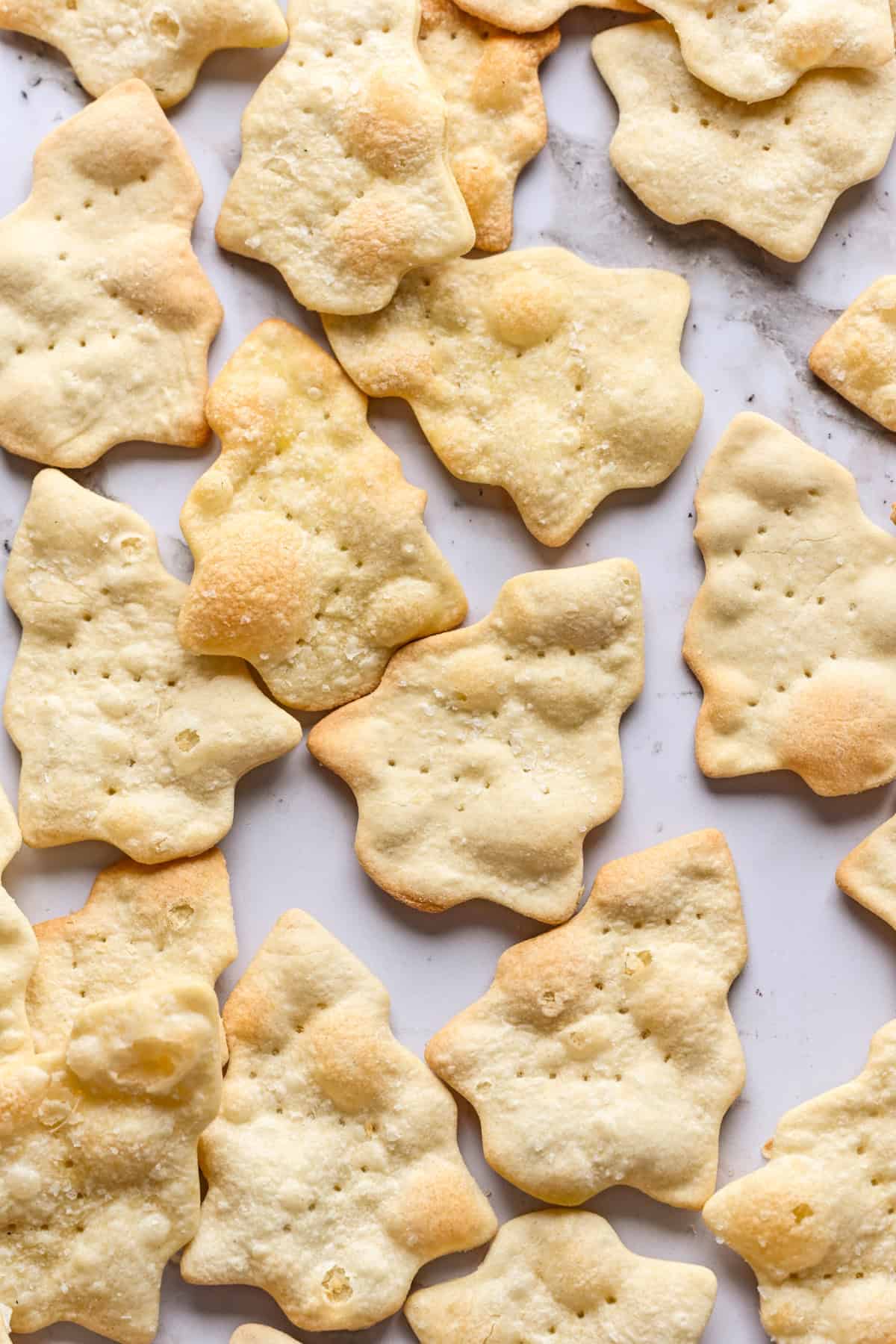 bovenaanzicht van kerstboomvormige crackers op marmer.
