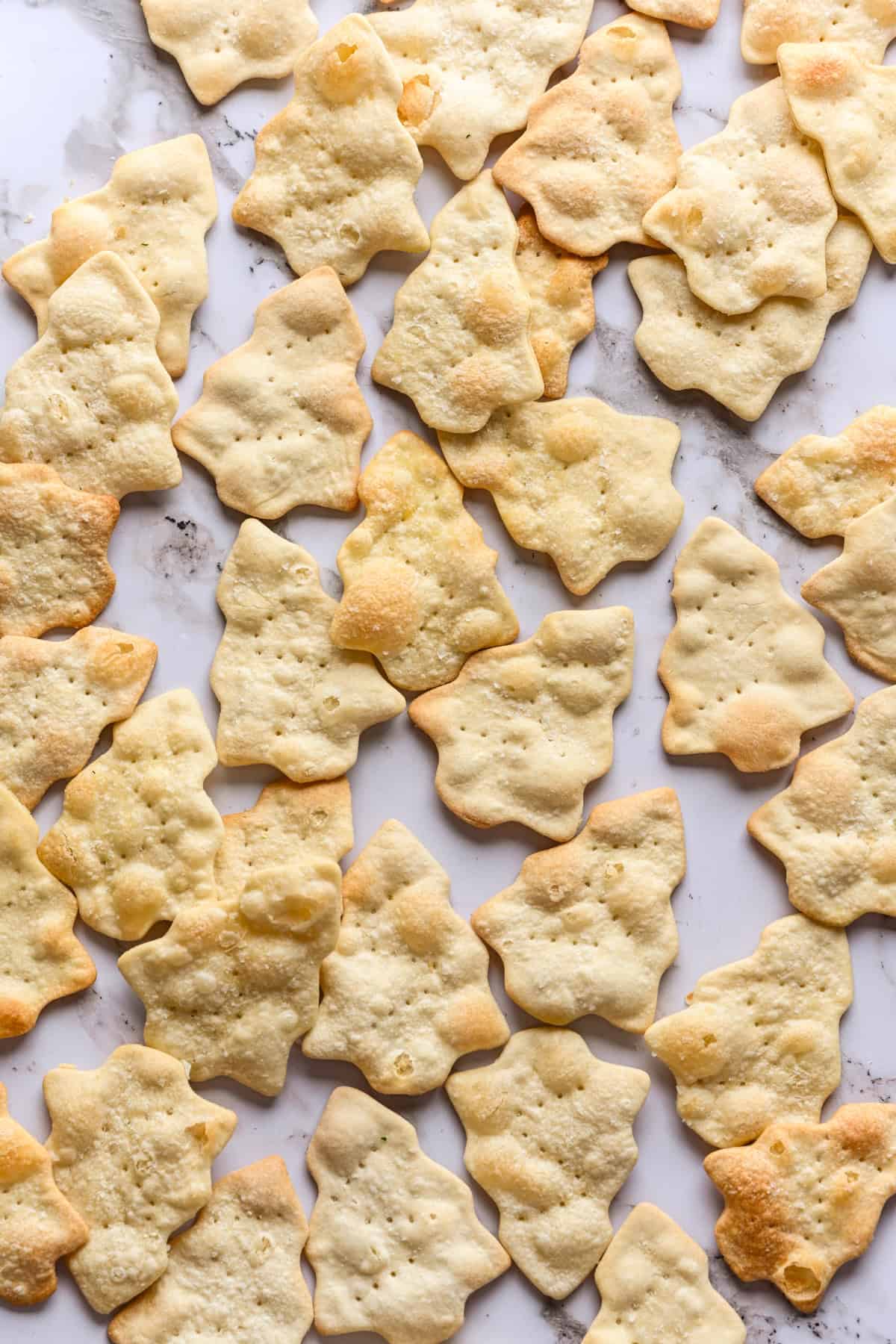 bovenaanzicht van kerstboomvormige crackers op marmer.
