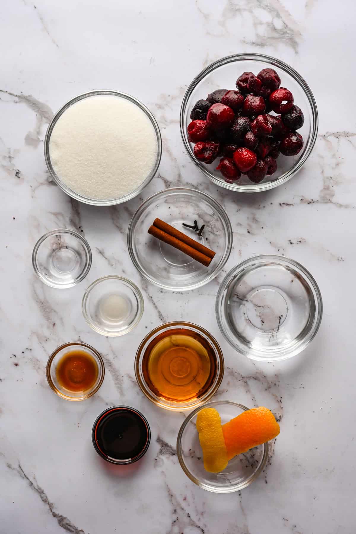 Bovenaanzicht van ingrediënten voor cocktailkersen in kleine prep-kommen.