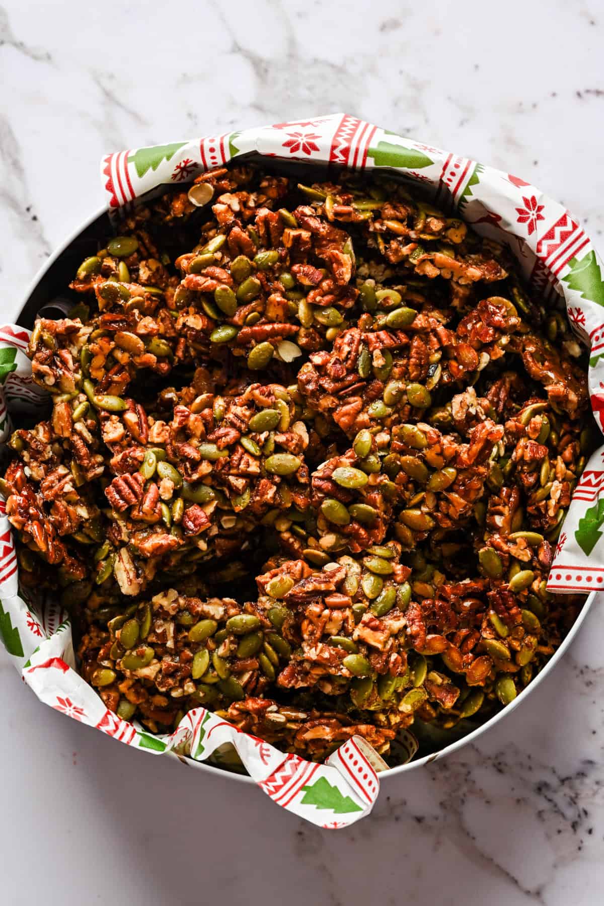 Pecan pepita brosse stukjes in een kerstcadeaublikje.