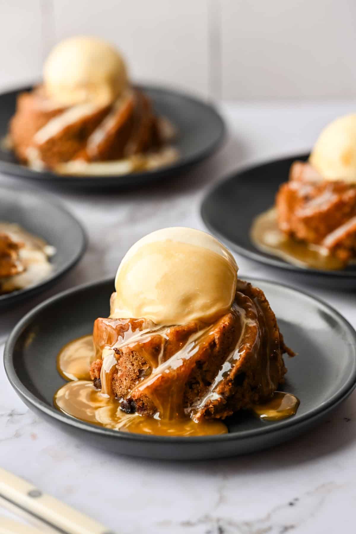 Mini vijgenpudding gegarneerd met ijs en karamelsaus.