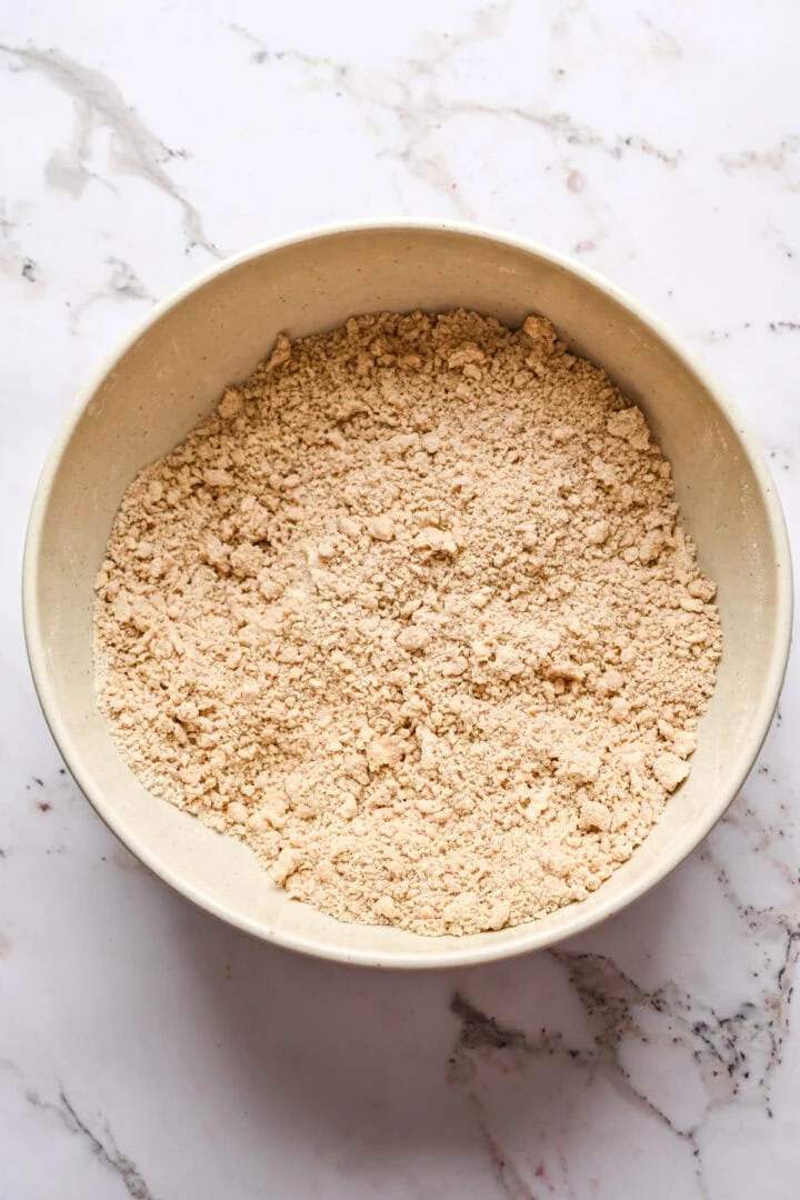 Droge ingrediënten van vijgenpudding gemengd met geraspte bevroren boter en bakvet.