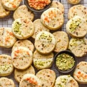 Bovenaanzicht van panettonekoekjes gedoopt in witte chocolade en gegarneerd met pistachenoten en gekonfijte sinaasappels.