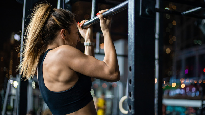 vrouw doet een pull-up in een sportschool