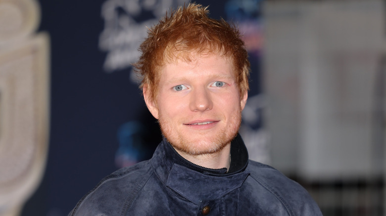 Close-up van Ed Sheeran in een suède blauw jasje.