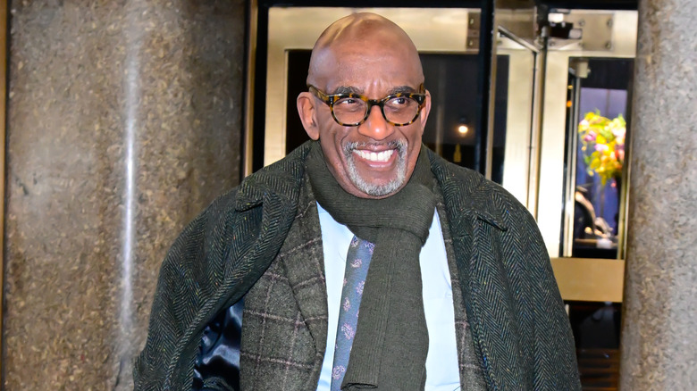 Al Roke, gehuld in jassen, glimlachte terwijl hij naar rechts keek.