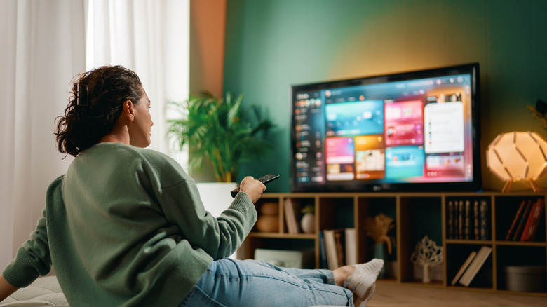 vrouw thuis beslissen wat ze kijken op een tv-streamingdienst