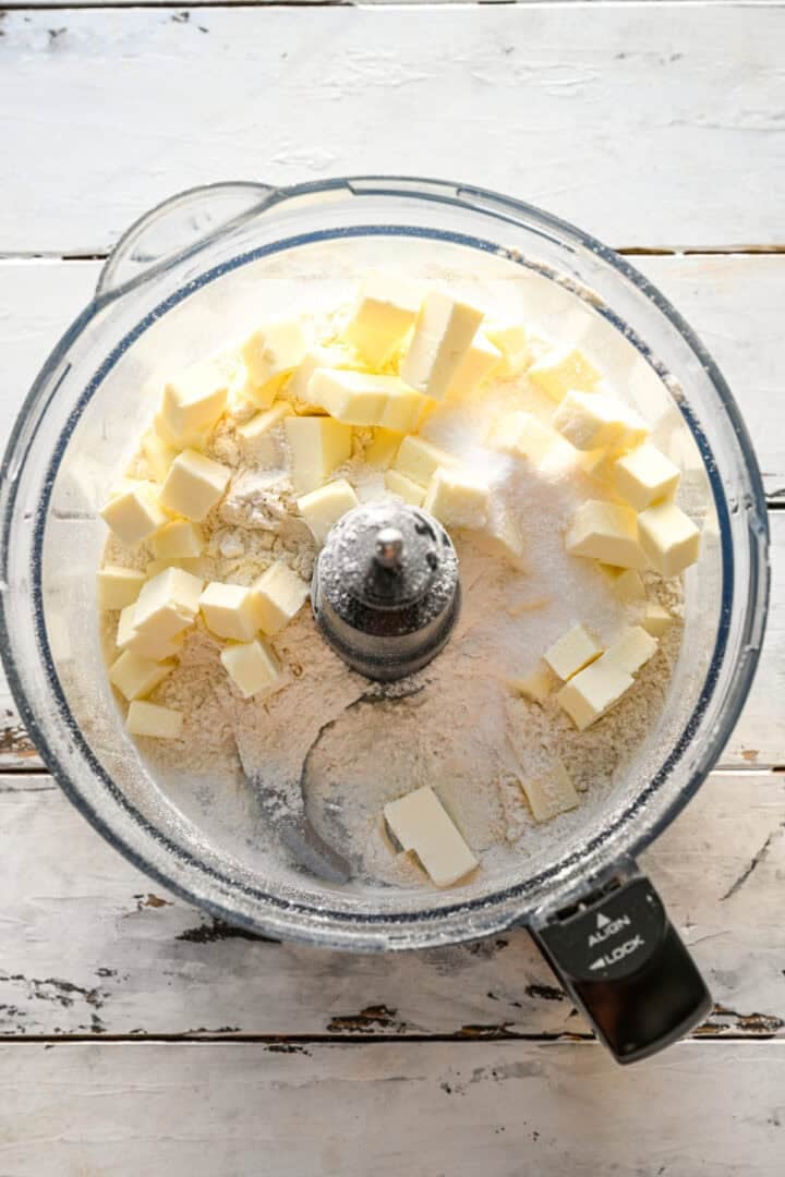 bovenaanzicht van pop-taartdeegingrediënten in de keukenmachine voordat ze met elkaar worden gemengd.