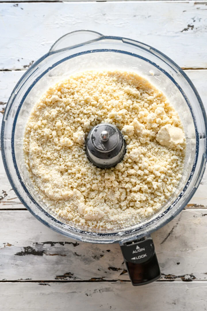 bovenaanzicht van pop-taartdeegingrediënten in de keukenmachine na het samenmengen.