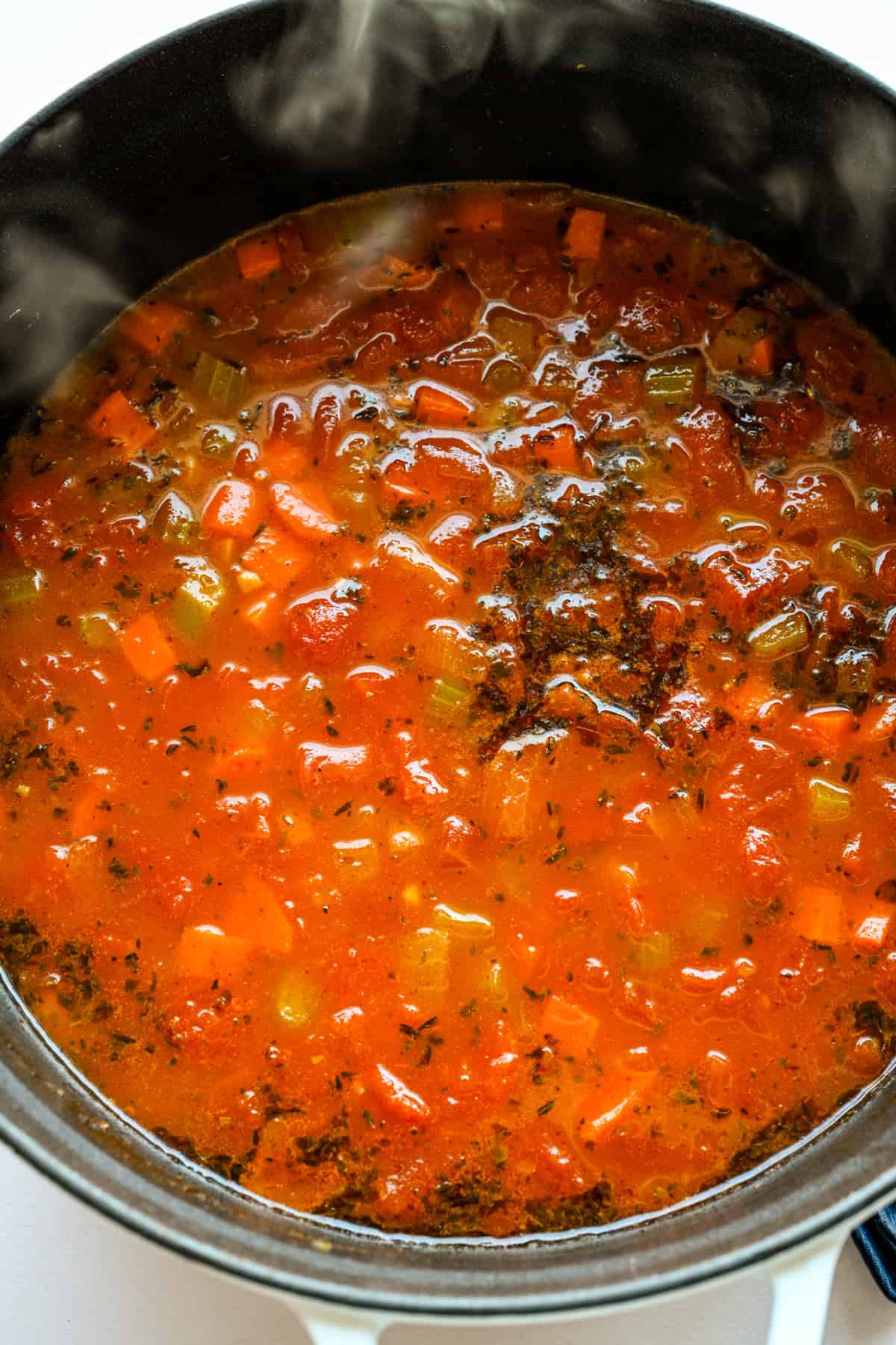 Bouillon en tomaten toegevoegd aan de pot.