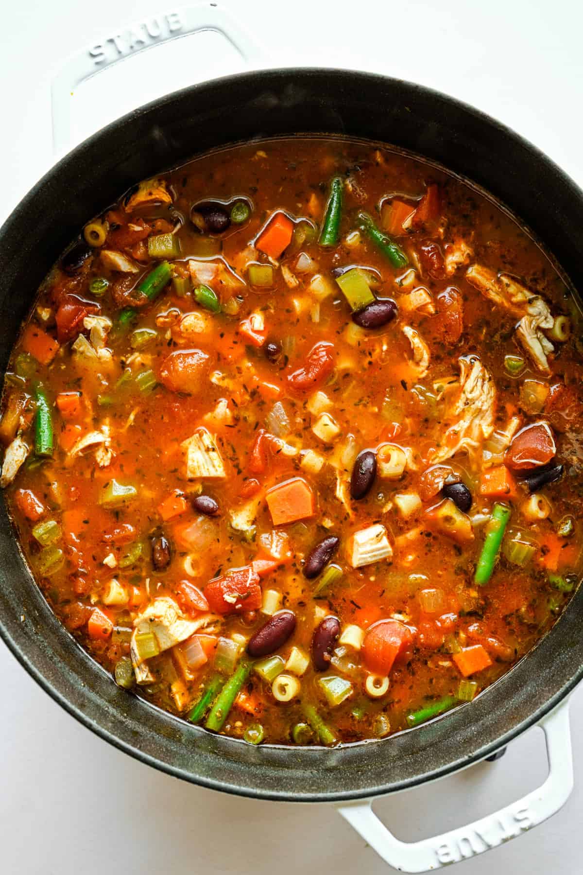 Pasta, sperziebonen en kip gestoofd in de pan met de rest van de ingrediënten.