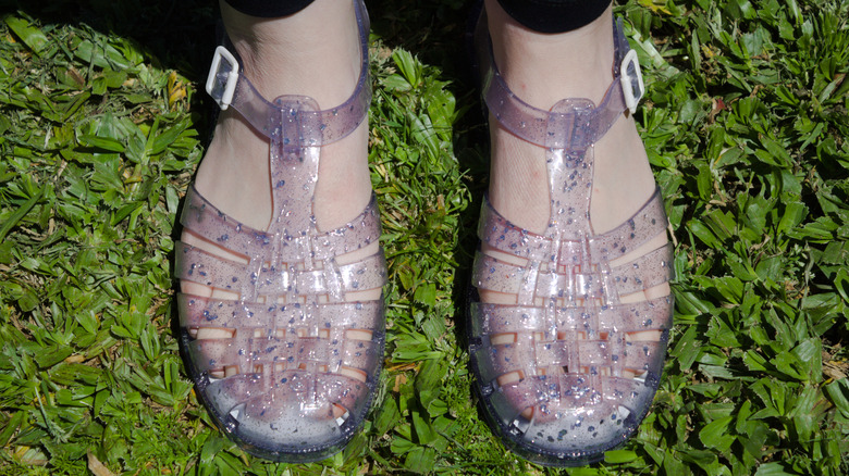 Vrouw die transparante plastic schoenen modelleert, ook bekend als gelei