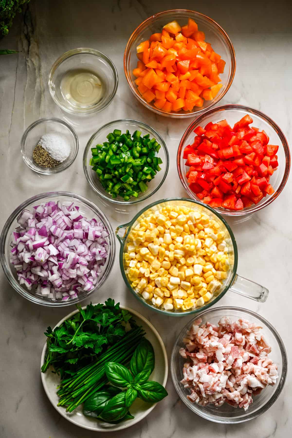 bovenaanzicht van ingrediënten voor confetti-maïs in individuele kommen.