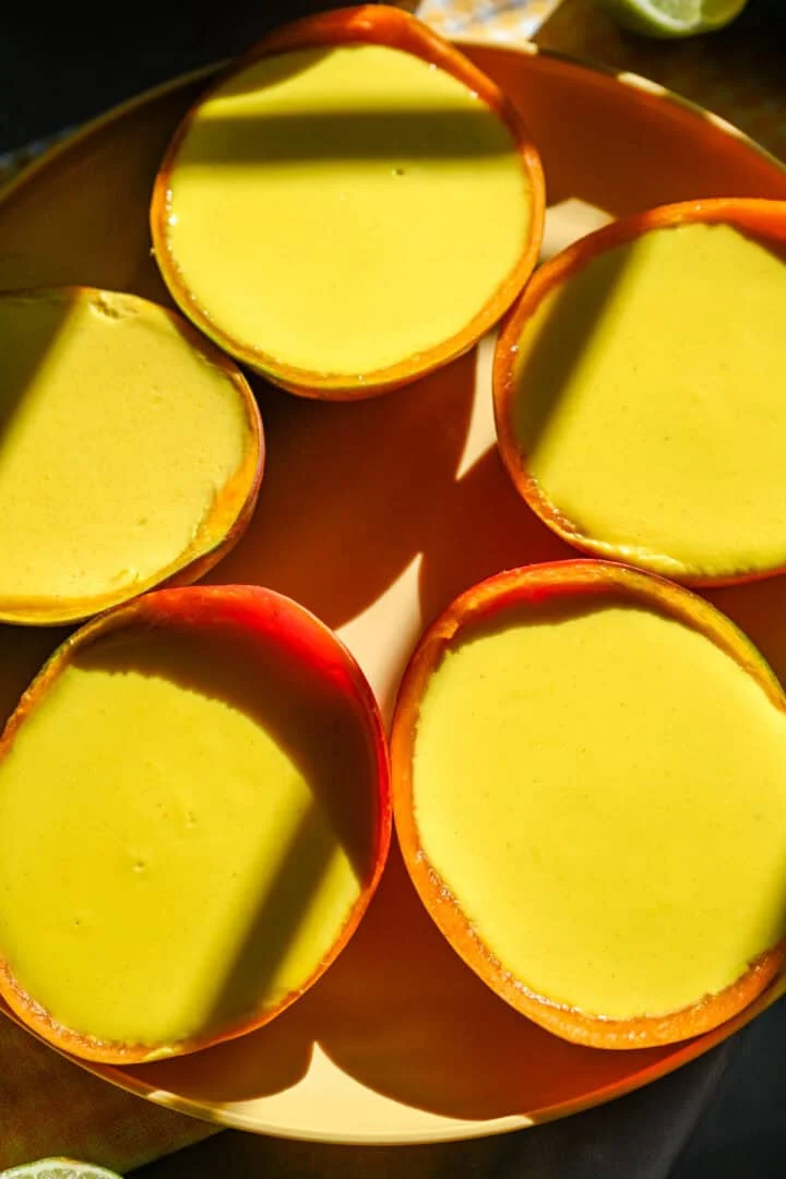 Bovenaanzicht van mango possets op een bord.