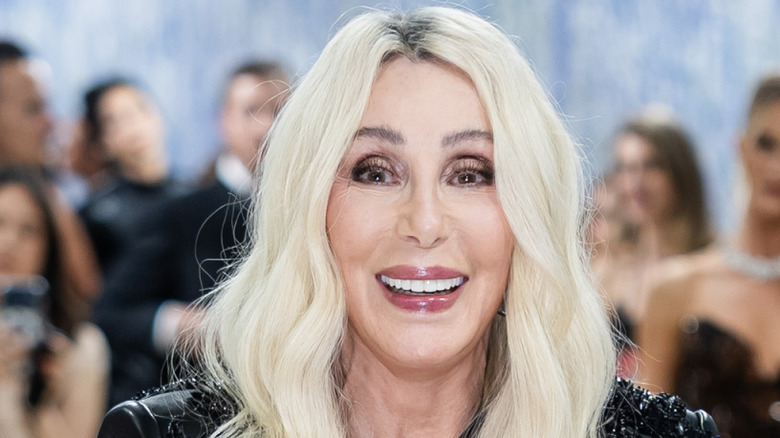 Cher lacht naar de camera tijdens een rode loper-evenement