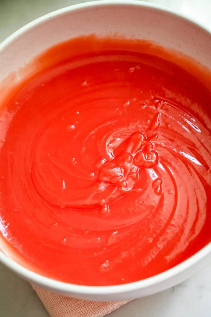Luchtmening van watermeloenpudding in een witte kom.