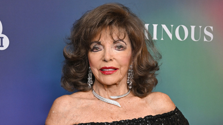 Joan Collins poseert in een zwarte jurk