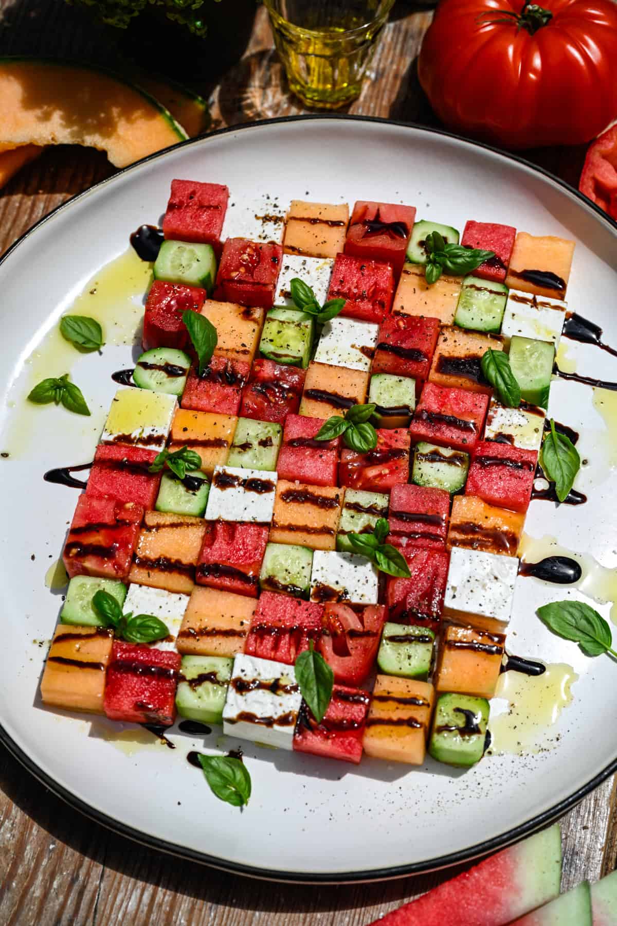 bovenaanzicht van watermeloen schaakbordsalade met vierkantjes meloen, komkommer, tomaat en feta.