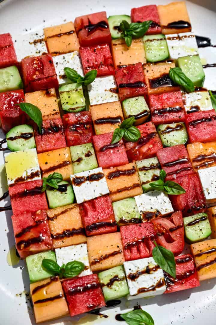 bovenaanzicht van watermeloen schaakbordsalade met vierkantjes meloen, komkommer, tomaat en feta.
