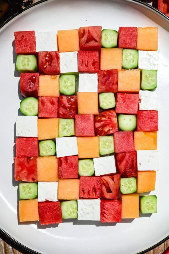 bovenaanzicht van watermeloen schaakbordsalade met vierkantjes meloen, komkommer, tomaat en feta.