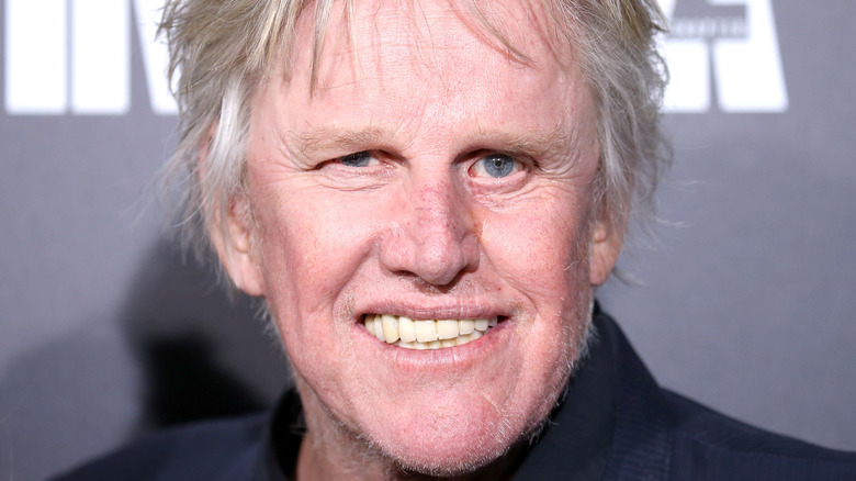 Gary Busey lacht naar de camera tijdens een publiciteitsevenement