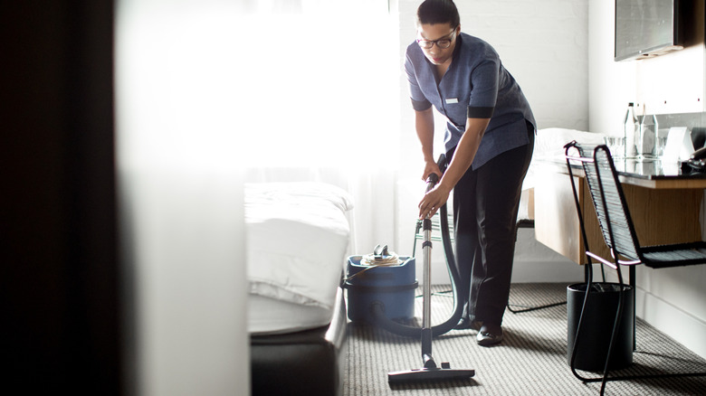 Huishoudster stofzuigt de hotelvloer