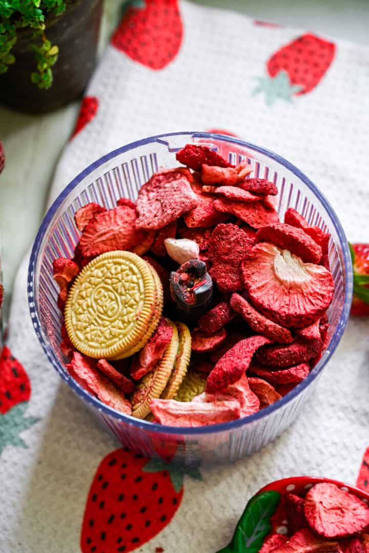 gevriesdroogde aardbeien en vanillekoekjes in de keukenmachine voordat u ze mengt. 
