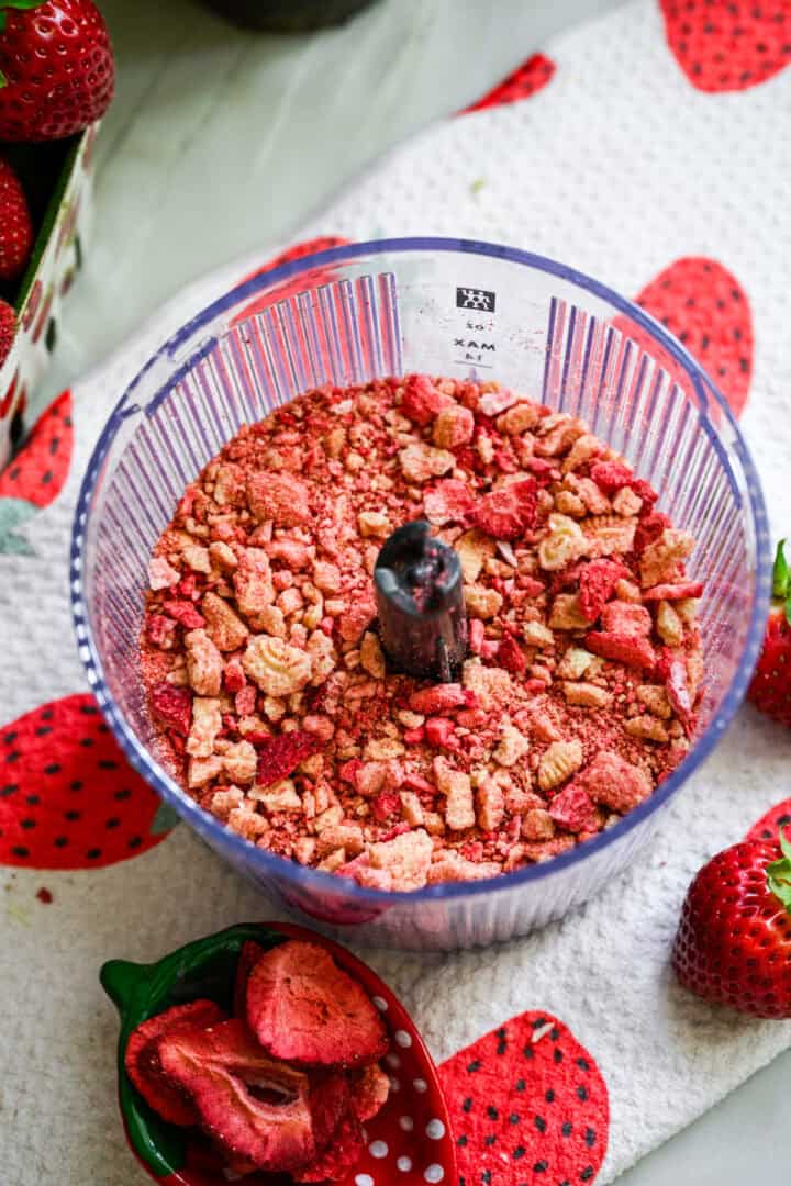 gevriesdroogde aardbeien en vanillekoekjes in de keukenmachine na het mengen.