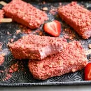 2 Strawberry Shortcake-ijsjes op elkaar gestapeld met een hapje uit de bovenste.