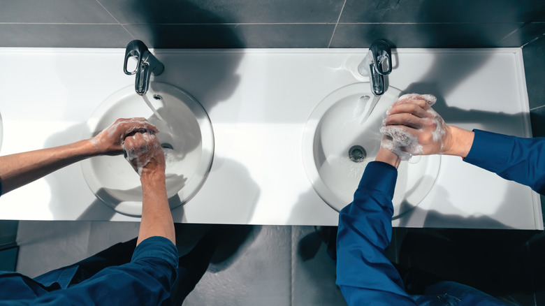 Twee mensen wassen hun handen in het toilet