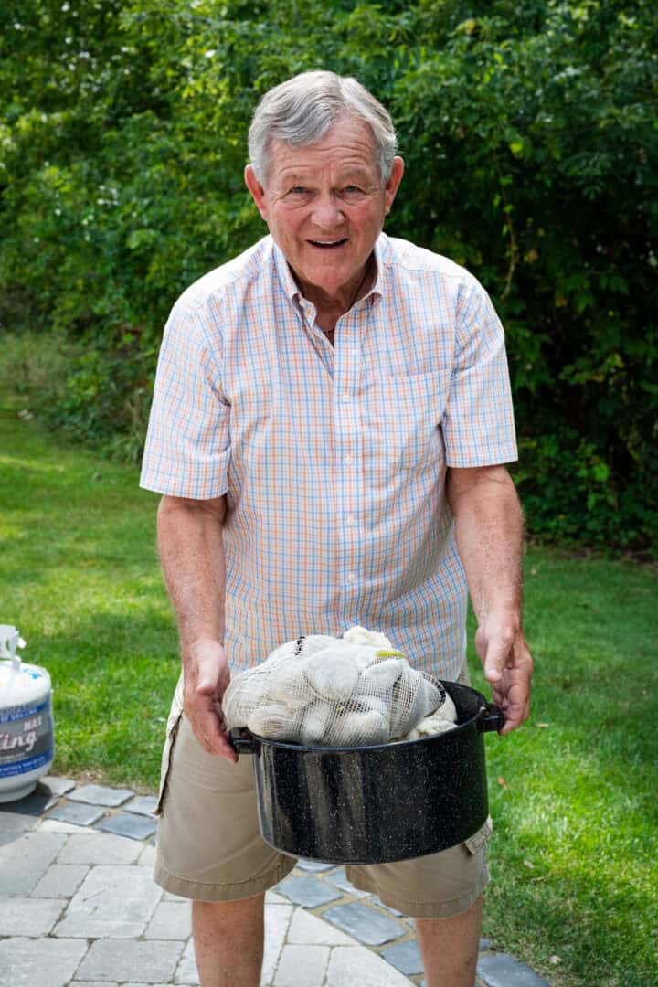 Opa houdt een pot mosselen vast. 