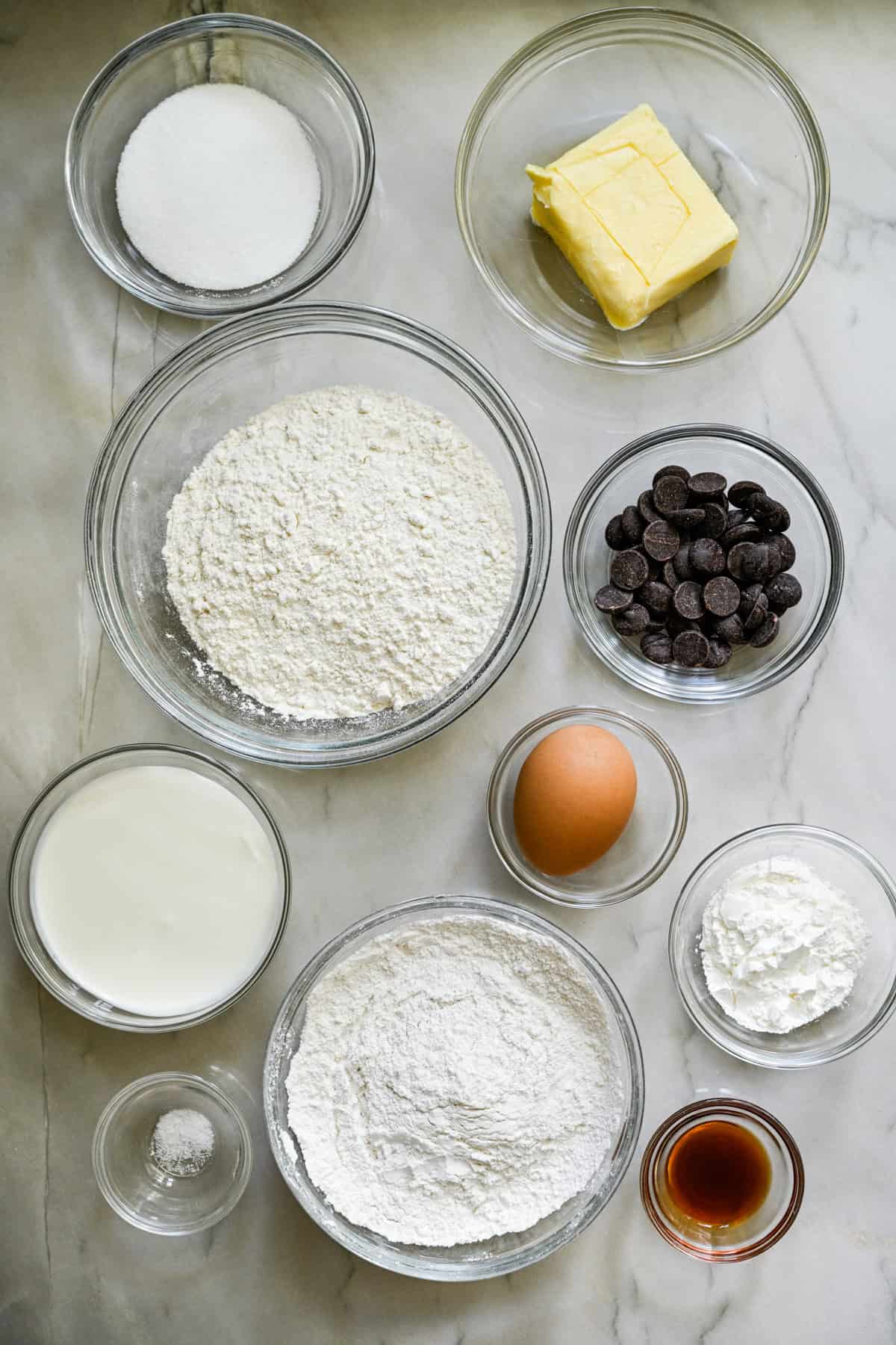 bovenaanzicht van ingrediënten voor zelfgemaakte milanos in aparte kleine glazen kommen.