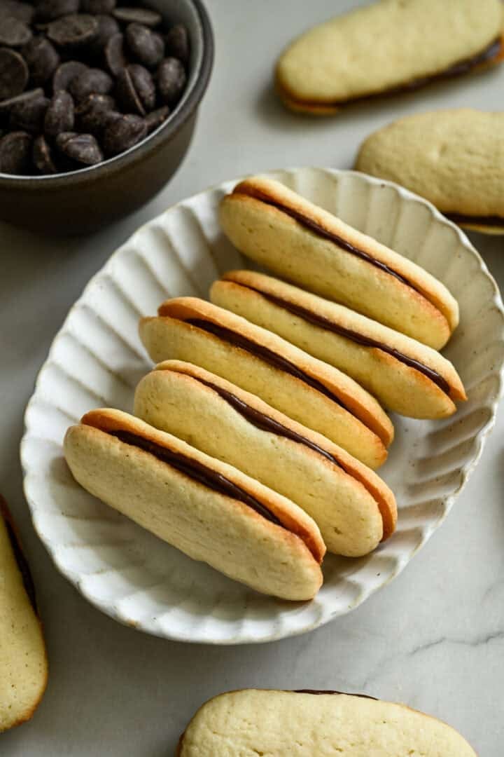 45 graden zicht op een stapel zelfgemaakte Milano-koekjes in een witte ovale kom.