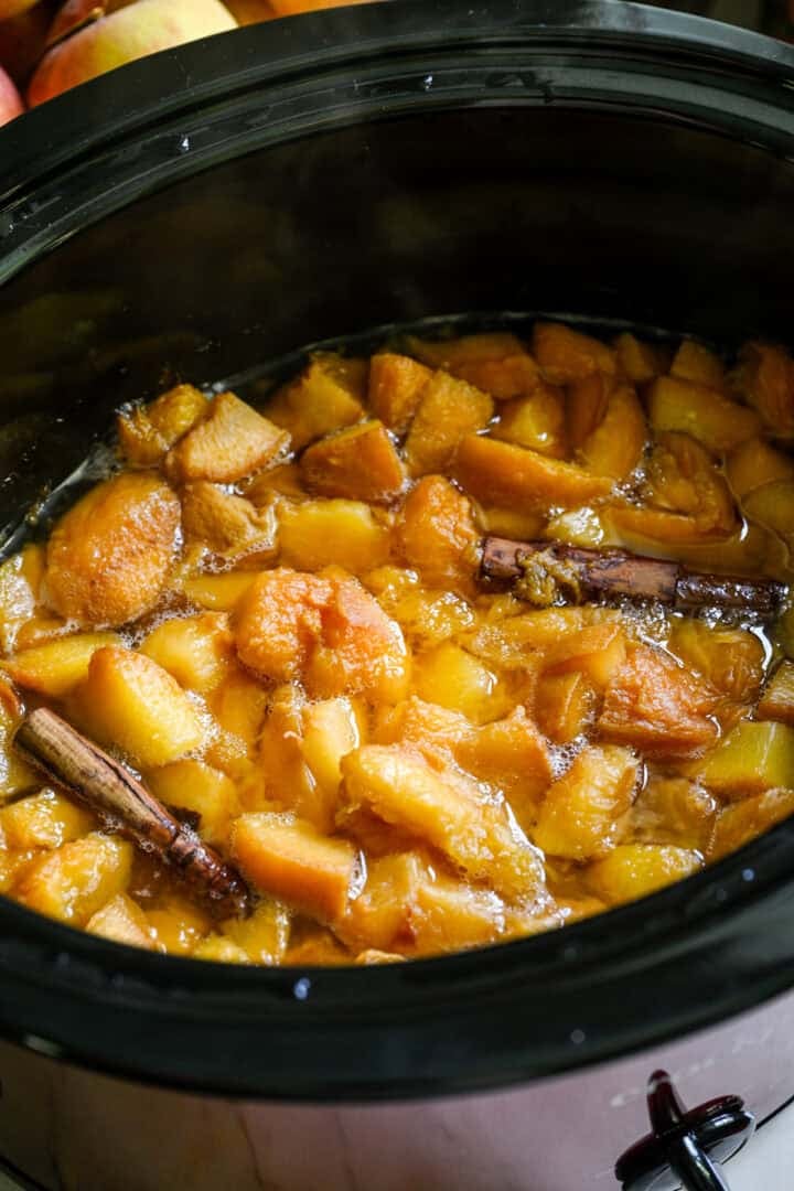 Bovenaanzicht van perzikboter in een slowcooker.
