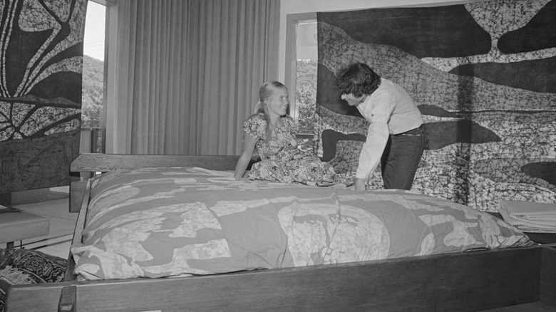 Een vrouw luistert naar een verkoper van Come Together Waterbeds die vertelt over de deugden van waterbedden.