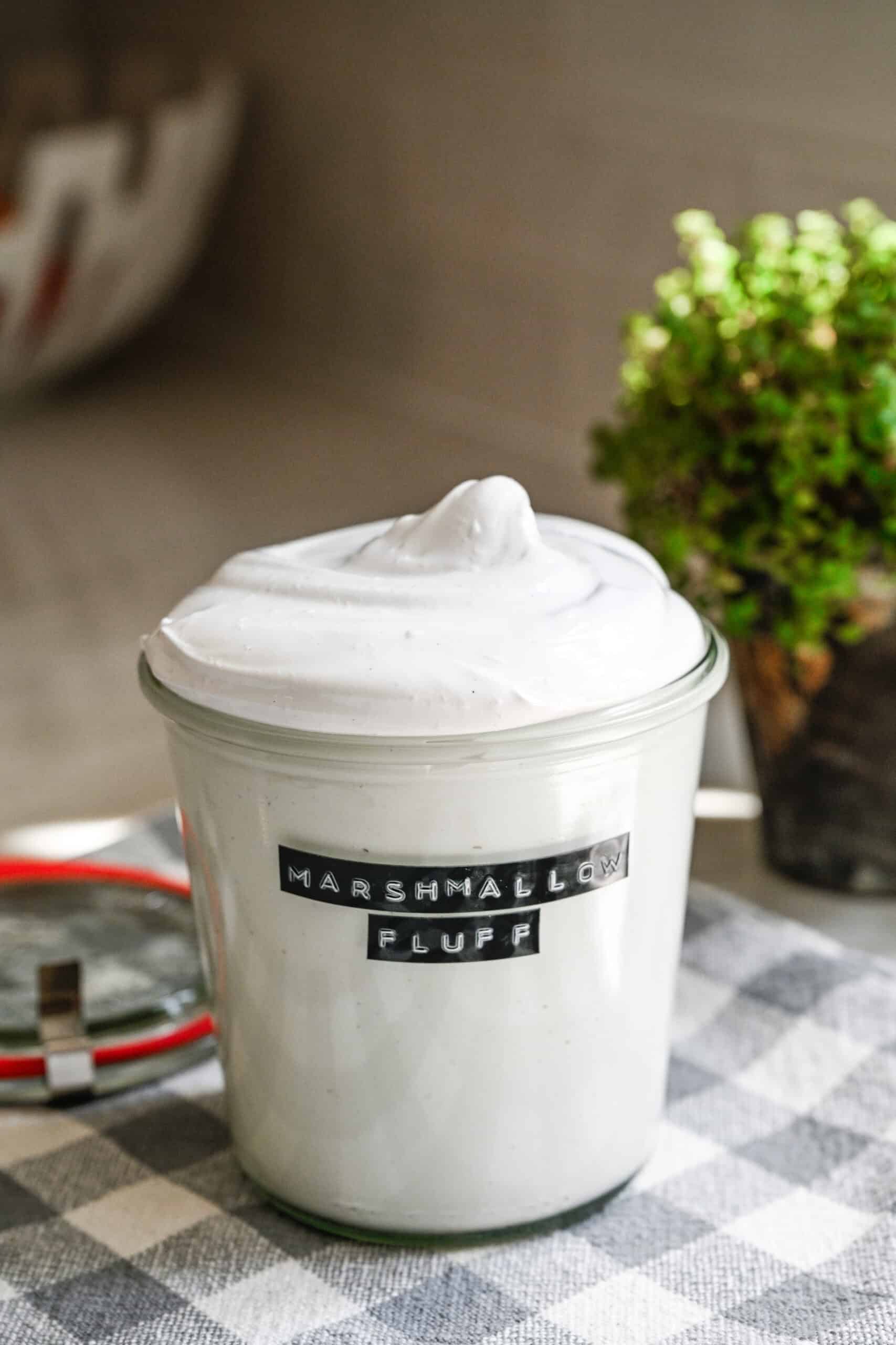 Close-up van zelfgemaakte marshmallow pluisjes in een glazen pot.